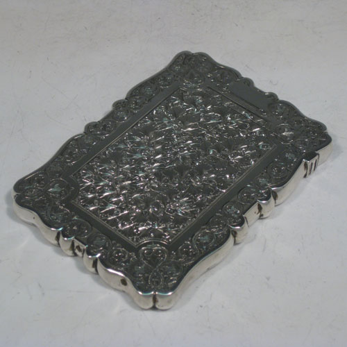 Antique Victorian sterling silver calling card case, having a shaped rectangular body with hand-engraved floral decoration (gingko leaves), and a side-hinged lid. Made in Birmingham in 1879. The dimensions of this fine hand-made silver card case are length 10 cms (4 inches), width 7 cms (2.75 inches), and it weighs approx. 60g (2 troy ounces).