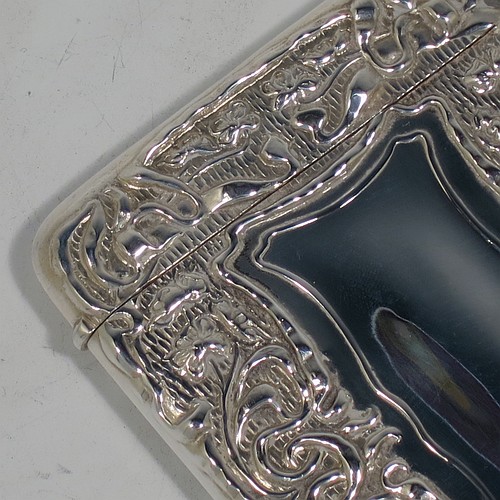 A very pretty Antique Edwardian Sterling Silver Art Nouveau card case, having a hand-chased rectangular body with floral and scroll decoration, a hanged lid, and two vacant cartouches on either side. Made by Cornelius Saunders and Frank Shepherd of Birmingham in 1905. The dimensions of this fine hand-made antique silver card case are length 9.5 cms (3.75 inches), width 7 cms (2.75 inches), and it weighs approx. 69g (2.2 troy ounces).