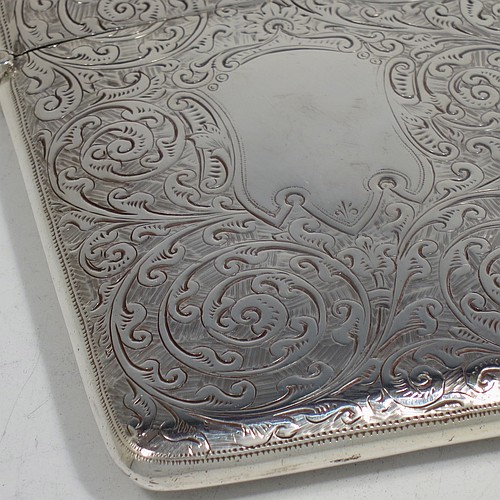 A very pretty Antique Victorian Sterling Silver calling card case, having a rectangular body with rounded shoulders, hand-engraved floral decoration, a vacant central cartouche on one side, and a side-hinged lid. Made by George Loveridge of Birmingham in 1898. The dimensions of this fine hand-made antique silver card case are length 10 cms (4 inches), width 7.5 cms (3 inches), and it weighs approx. 88g (2.8 troy ounces).