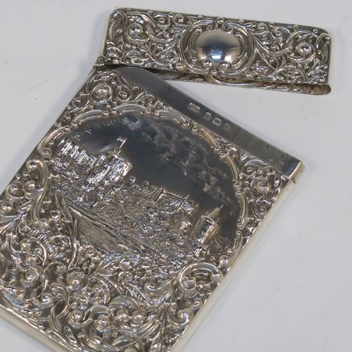 A very pretty Antique Edwardian Sterling Silver Castle-Top card case, having a hand-chased rectangular body with floral and scroll decoration, together with a scene of Royal Windsor Castle on one side, a hanged lid, and a vacant cartouches on the other side. This beautiful antique silver card case was made by Crisford and Norris of Birmingham in 1906. The dimensions of this fine hand-made antique silver card case are length 10 cms (4 inches), width 7 cms (2.75 inches), and it weighs approx. 58g (1.9 troy ounces).