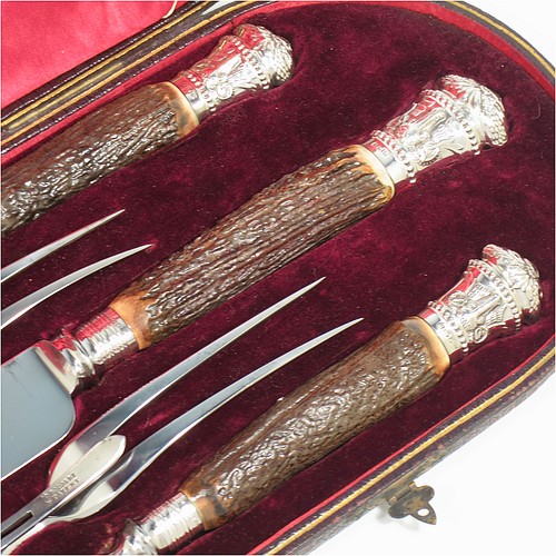 A very handsome, large, and complete Antique Victorian Sterling Silver and deer antler horn carving set, consisting of two forks with working guards, two knives, and one sharpening steel, with original bone antler handles and silver ferrules with hand-chased bead-work and rams heads, all in their original red silk and maroon velvet-lined presentation box. Made by James Round of Sheffield in 1886. The dimensions of this fine hand-made antique silver and bone handled carving set are length of longest knife 43 cms (17 inches), and length of shortest fork 28 cms (11 inches)