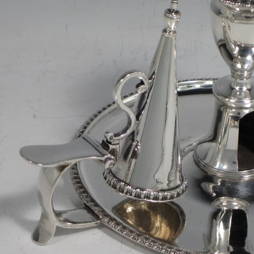 An Antique Georgian Sterling Silver pair of chamber-sticks, having plain round bodies, removable nozzles, original dunce-cap snuffers, and applied gadroon-edged borders. Made by Daniel Smith & Robert Sharp of London in 1788. The dimensions of these fine hand-made silver chambersticks are height 9 cms (3.4 inches), diameter 14 cms (5.5 inches), and they weigh a total of approx. 580g (18.7 troy ounces). Please note that both items are crested.