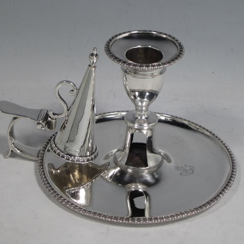 An Antique Georgian Sterling Silver pair of chamber-sticks, having plain round bodies, removable nozzles, original dunce-cap snuffers, and applied gadroon-edged borders. Made by Daniel Smith & Robert Sharp of London in 1788. The dimensions of these fine hand-made silver chambersticks are height 9 cms (3.4 inches), diameter 14 cms (5.5 inches), and they weigh a total of approx. 580g (18.7 troy ounces). Please note that both items are crested.