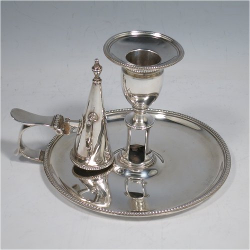 An Antique Georgian Sterling Silver chamber-stick, having a round base, a handle with thumb-piece, an original removable dunce-cap extinguisher, an original removable nozzle, and with applied bead-edged borders. Made by John Crouch & Thomas Hannam of London in 1782. The dimensions of this fine hand-made silver chamberstick are diameter 13.5 cms (5.3 inches), height 10 cms (4 inches), and it weighs approx. 245g (7.9 troy ounces).   