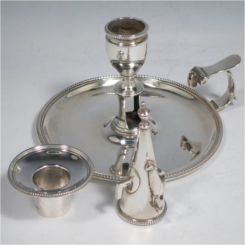 An Antique Georgian Sterling Silver chamber-stick, having a round base, a handle with thumb-piece, an original removable dunce-cap extinguisher, an original removable nozzle, and with applied bead-edged borders. Made by John Crouch & Thomas Hannam of London in 1782. The dimensions of this fine hand-made silver chamberstick are diameter 13.5 cms (5.3 inches), height 10 cms (4 inches), and it weighs approx. 245g (7.9 troy ounces).