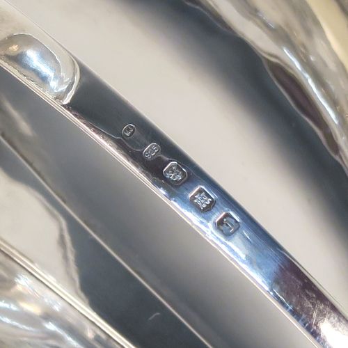 A very individual Scottish Sterling Silver modernistic style chamber-stick, having a plain oval leaf-form body, with a scroll-work handle, a plain round fixed nozzle, and sitting on a flat base. This unusual silver chamberstick was made in Edinburgh in 2008. The dimensions of these fine hand-made silver chambersticks are length 18 cms (7 inches), width 10 cms (4 inches), height 9 cms (3.5 inches), and it weighs approx. 162g (5.2 troy ounces).
