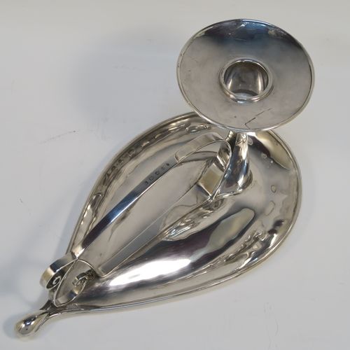 A very individual Scottish Sterling Silver modernistic style chamber-stick, having a plain oval leaf-form body, with a scroll-work handle, a plain round fixed nozzle, and sitting on a flat base. This unusual silver chamberstick was made in Edinburgh in 2008. The dimensions of these fine hand-made silver chambersticks are length 18 cms (7 inches), width 10 cms (4 inches), height 9 cms (3.5 inches), and it weighs approx. 162g (5.2 troy ounces).