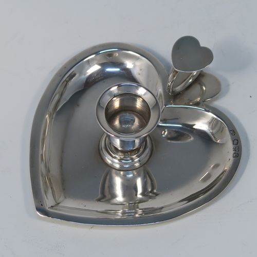 A very pretty Antique Victorian Sterling Silver miniature chamber-stick, having a plain heart-shaped body, with a ring handle and heart-shaped thumb-piece, a plain round fixed nozzle, and sitting on a flat base. This unusual heart-shaped silver chamberstick was made by William Aitkens of Chester in 1899. The dimensions of these fine hand-made antique silver miniature chamberstick are length 10 cms (4 inches), width 9.5 cms (3.75 inches), height 4 cms (1.5 inches), and it weighs approx. 52g (1.7 troy ounces).