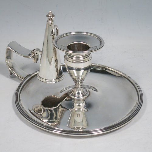 An Antique Georgian Sterling Silver chamber-stick, having a round base, a cast plain scroll handle, an original removable dunce-cap extinguisher, an original removable nozzle, and with applied reed-edged borders. Made by Samuel & George Whitford of London in 1806. The dimensions of this fine hand-made antique silver chamberstick are diameter 13.5 cms (5.25 inches), height 9.5 cms (3.75 inches), and it weighs approx. 326g (10.5 troy ounces).   