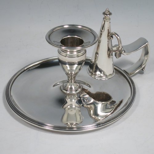 An Antique Georgian Sterling Silver chamber-stick, having a round base, a cast plain scroll handle, an original removable dunce-cap extinguisher, an original removable nozzle, and with applied reed-edged borders. Made by Samuel & George Whitford of London in 1806. The dimensions of this fine hand-made antique silver chamberstick are diameter 13.5 cms (5.25 inches), height 9.5 cms (3.75 inches), and it weighs approx. 326g (10.5 troy ounces).