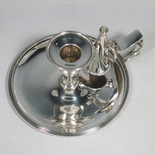 An Antique Georgian Sterling Silver chamber-stick, having a round base, a cast plain scroll handle, an original removable dunce-cap extinguisher, an original removable nozzle, and with applied reed-edged borders. Made by Samuel & George Whitford of London in 1806. The dimensions of this fine hand-made antique silver chamberstick are diameter 13.5 cms (5.25 inches), height 9.5 cms (3.75 inches), and it weighs approx. 326g (10.5 troy ounces).