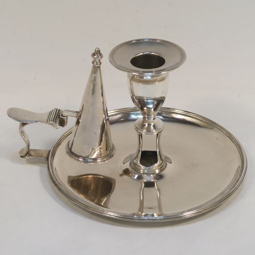 A handsome Antique Georgian Sterling Silver chamber-stick, having a round base, a scroll handle, an original removable dunce-cap extinguisher, an original removable nozzle, and with applied reed-edged borders. This beautiful antique silver chamberstick was made by John Huston of London in 1789. The dimensions of this fine hand-made silver chamberstick are diameter 14 cms (5.5 inches), height 9 cms (3.5 inches), and it weighs approx. 283g (9 troy ounces).   