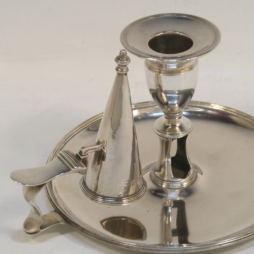 A handsome Antique Georgian Sterling Silver chamber-stick, having a round base, a scroll handle, an original removable dunce-cap extinguisher, an original removable nozzle, and with applied reed-edged borders. This beautiful antique silver chamberstick was made by John Huston of London in 1789. The dimensions of this fine hand-made silver chamberstick are diameter 14 cms (5.5 inches), height 9 cms (3.5 inches), and it weighs approx. 283g (9 troy ounces).