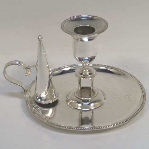 A very pretty Antique Georgian Sterling Silver chamber-stick, having a round base, a scroll handle, an original removable dunce-cap extinguisher, an original removable nozzle, and with applied bead-edged borders. This beautiful antique silver chamberstick was made by Hester Bateman of London in 1785. The dimensions of this fine hand-made silver chamberstick are diameter 15 cms (6 inches), height 11 cms (4.25 inches), and it weighs approx. 313g (10 troy ounces). Please note that this item is crested.
