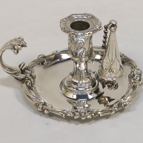 A very pretty Antique early Victorian Sterling Silver small chamber-stick for taper-stick size candles, having a round body with applied scroll and floral borders, a cast scroll handle, an original removable dunce-cap extinguisher with a security chain, and an original removable nozzle. This beautiful antique silver chamberstick was made by the Barnard Brothers of London in 1838. The dimensions of this fine hand-made silver chamberstick are diameter 9 cms (3.5 inches), height 5.5 cms (2.25 inches), and it weighs approx. 117g (3.8 troy ounces).  