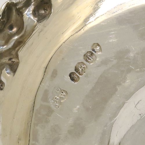 A very pretty Antique early Victorian Sterling Silver small chamber-stick for taper-stick size candles, having a round body with applied scroll and floral borders, a cast scroll handle, an original removable dunce-cap extinguisher with a security chain, and an original removable nozzle. This beautiful antique silver chamberstick was made by the Barnard Brothers of London in 1838. The dimensions of this fine hand-made silver chamberstick are diameter 9 cms (3.5 inches), height 5.5 cms (2.25 inches), and it weighs approx. 117g (3.8 troy ounces).