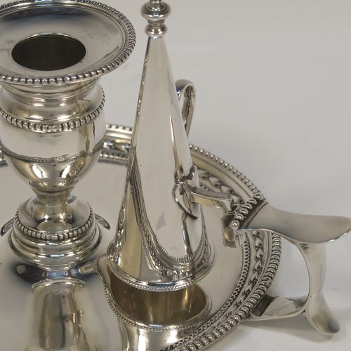 A very pretty Antique Victorian Sterling Silver chamber-stick, having a plain body with a round base, a cast plain scroll side-handle, an original removable dunce-cap extinguisher, an original removable nozzle, and with applied floral and bead-edged borders. This beautiful silver chamberstick was made by James Dixon and Sons of Sheffield of Sheffield in 1900. The dimensions of this fine hand-made antique silver chamberstick are diameter 13.5 cms (5.25 inches), height 9.5 cms (3.75 inches), and it weighs approx. 258g (8.3 troy ounces).