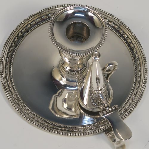 A very pretty Antique Victorian Sterling Silver chamber-stick, having a plain body with a round base, a cast plain scroll side-handle, an original removable dunce-cap extinguisher, an original removable nozzle, and with applied floral and bead-edged borders. This beautiful silver chamberstick was made by James Dixon and Sons of Sheffield of Sheffield in 1900. The dimensions of this fine hand-made antique silver chamberstick are diameter 13.5 cms (5.25 inches), height 9.5 cms (3.75 inches), and it weighs approx. 258g (8.3 troy ounces).