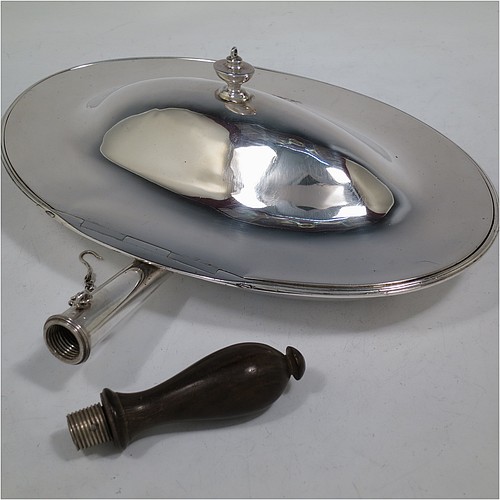 A very handsome Antique Georgian Sterling Silver cheese dish, having a very plain oval body with reeded borders, a cast urn-shaped finial, and a flat hidden hinge, attached to a hollow oval hot-water jacket base with removable oak wood-turned handle and a security chain to hold the lid at an angle to reflect heat from fire onto cheese. Made by John King of London in 1788. The dimensions of this fine hand-made antique silver cheese dish are length (inc. handle) 29 cms (11.5 inches), with 25.5 cms (10 inches), height 8 cms (3 inches), and it weighs approx. 850g (27 troy ounces). Please note that this item is crested.