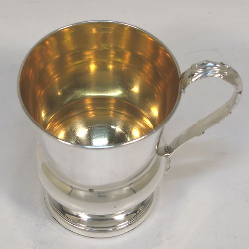 A handsome Antique Georgian Sterling Silver christening mug, having a plain round bellied body with a gold-gilt interior, an acanthus leaf scroll handle, and sitting on a pedestal foot. This elegant antique silver christening mug was made by Matthew Boulton of Birmingham in 1823. The dimensions of this fine hand-made antique silver christening mug are height 9.5 cms (3.75 inches), length 10 cms (4 inches), and it weighs approx. 128g (4 troy ounces).