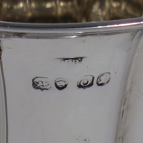 An Antique Georgian Sterling Silver christening mug, having a round bellied body, with hand-chased melon style fluted decoration, an acanthus leaf scroll handle, and sitting on a pedestal foot. Made by William Bateman of London in 1829. The dimensions of this fine hand-made antique silver christening mug are height 11 cms (4.3 inches), length 11.5 cms (4.5 inches), and it weighs approx. 185g (6 troy ounces).