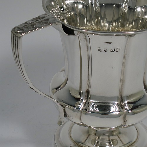 An Antique Georgian Sterling Silver christening mug, having a round bellied body, with hand-chased melon style fluted decoration, an acanthus leaf scroll handle, and sitting on a pedestal foot. Made by William Bateman of London in 1829. The dimensions of this fine hand-made antique silver christening mug are height 11 cms (4.3 inches), length 11.5 cms (4.5 inches), and it weighs approx. 185g (6 troy ounces).