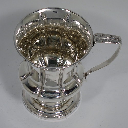 An Antique Georgian Sterling Silver christening mug, having a round bellied body, with hand-chased melon style fluted decoration, an acanthus leaf scroll handle, and sitting on a pedestal foot. Made by William Bateman of London in 1829. The dimensions of this fine hand-made antique silver christening mug are height 11 cms (4.3 inches), length 11.5 cms (4.5 inches), and it weighs approx. 185g (6 troy ounces).