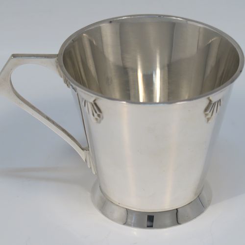 A very handsome Art Deco style Sterling Silver christening mug, having a plain round body with tapering sides, angular side handle, with four applied sunburst decals under the top rim, and sitting on a plain collet foot. This elegant silver christening mug was made by Henry Wigfall  of Sheffield in 1932. The dimensions of this fine hand-made Art Deco silver christening mug are height 7 cms (2.75 inches), length 10 cms (4 inches), and it weighs approx. 109g (3.5 troy ounces).  
