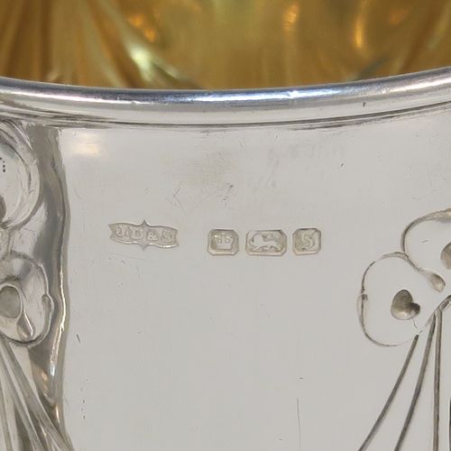A very pretty Antique Edwardian Sterling Silver christening mug, having a round bellied body, with hand-chased ribbons, swags, and lotus leaf decoration, a cast scroll side-handle, a gold-gilt interior, and sitting on a pedestal foot. This beautiful antique silver christening mug was made by James Dixon and Sons of Sheffield in 1910. The dimensions of this fine hand-made antique silver christening mug are height 10 cms (4 inches), length 10 cms (4 inches), and it weighs approx. 151g (4.9 troy ounces).