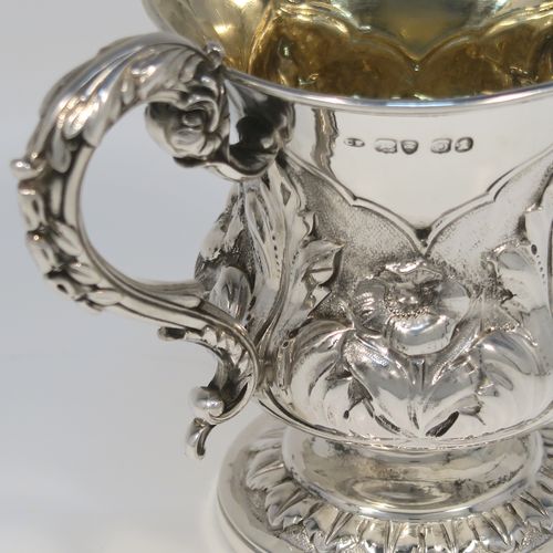 A beautiful Antique Georgian Sterling Silver christening mug, having a round bellied body, with hand-chased floral and leaf style decoration, an acanthus leaf scroll handle, a gold-gilt interior, and sitting on a pedestal foot. This fantastic silver christening mug was made by Charles Fox of London in 1829. The dimensions of this fine hand-made antique silver christening mug are height 9.5 cms (3.75 inches), length 11.5 cms (4.5 inches), and it weighs approx. 142g (4.6 troy ounces).   