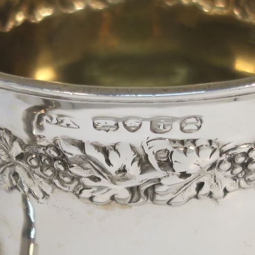A very handsome Antique Georgian Sterling Silver christening mug, having a round bellied Campagna style body, with an upper band of hand-chased grapevine work, a gold-gilt interior, an acanthus leaf scroll handle, and sitting on a pedestal foot. This elegant antique silver christening mug was made by Joseph Angell II of London in 1824. The dimensions of this fine hand-made antique silver christening mug are height 8.5 cms (3.3 inches), length 9 cms (3.5 inches), and it weighs approx. 121g (3.9 troy ounces).