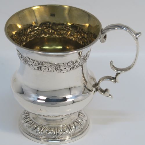 A very handsome Antique Georgian Sterling Silver christening mug, having a round bellied Campagna style body, with an upper band of hand-chased grapevine work, a gold-gilt interior, an acanthus leaf scroll handle, and sitting on a pedestal foot. This elegant antique silver christening mug was made by Joseph Angell II of London in 1824. The dimensions of this fine hand-made antique silver christening mug are height 8.5 cms (3.3 inches), length 9 cms (3.5 inches), and it weighs approx. 121g (3.9 troy ounces).