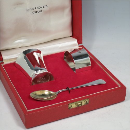 A Sterling Silver christening set, having an egg cup with gold-gilt interior, a spoon with gold-gilt bowl, and a napkin ring. All in a very plain style, and sitting in their original satin and velvet-lined red presentation box. Made by Payne & Son Ltd., of London in 1971/73. The dimensions of this fine hand-made silver christening set are length of spoon 11 cms (4.3 inches), height of egg cup 6 cms (2.25 inches), diameter of napkin ring 4.5 cms (1.75 inches), and the total weight is approx. 97g (3 troy ounces).   