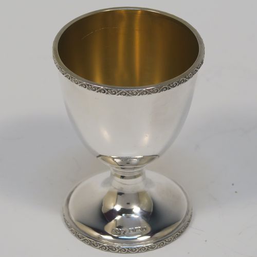 A handsome Sterling Silver three-piece christening set, consisting of a plain round napkin ring, a plain round egg cup with applied floral and scroll borders and a gold-gilt interior, and a plain Hanoverian pattern spoon with a gold-gilt bowl, all in their original cream satin and black velvet-lined presentation box. This elegant christening set was made by Turner and Simpson Birmingham in 1960 (the napkin ring was made by Henry Matthews of Birmingham in 1935). The dimensions of this fine hand-made silver christening set are length of spoon 10 cms (4 inches), diameter of napkin ring 4.5 cms (1.75 inches), height of egg cup 6.5 cms (2.75 inches), and the total weight is approx. 56g (1.8 troy ounces).