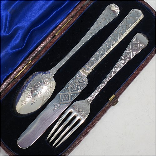 An Antique Victorian Sterling Silver christening set, having a knife, fork, and spoon, all hand-engraved with geometrical and floral work, and all sitting in their original dark blue satin and velvet-lined presentation box. Made by George Adams of London in 1871. The dimensions of this fine hand-made antique silver christening set are length of knife 19 cms (7.5 inches), with a total weight of approx. 100g (3 troy ounces).