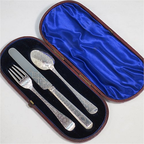 An Antique Victorian Sterling Silver christening set, having a knife, fork, and spoon, all hand-engraved with geometrical and floral work, and all sitting in their original dark blue satin and velvet-lined presentation box. Made by George Adams of London in 1871. The dimensions of this fine hand-made antique silver christening set are length of knife 19 cms (7.5 inches), with a total weight of approx. 100g (3 troy ounces).