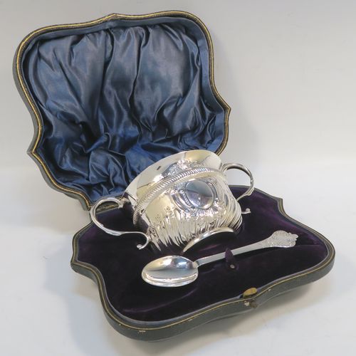 A pretty Antique Edwardian Sterling Silver christening set, consisting of a two-handled porringer with hand-chased fluted decoration, together with a serving spoon, all in their blue satin and velvet-lined presentation box. The porringer was made by Henry Stratford of London in 1908, whilst the spoon was made by Thomas Bradbury of London in 1897. The dimensions of this fine hand-made silver christening set are length of spoon 14 cms (5.5 inches), diameter of bowl 10 cms (4 inches), and the total weight is approx. 172g (5.5 troy ounces).  