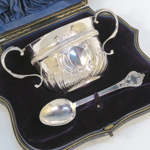 A pretty Antique Edwardian Sterling Silver christening set, consisting of a two-handled porringer with hand-chased fluted decoration, together with a serving spoon, all in their blue satin and velvet-lined presentation box. The porringer was made by Henry Stratford of London in 1908, whilst the spoon was made by Thomas Bradbury of London in 1897. The dimensions of this fine hand-made silver christening set are length of spoon 14 cms (5.5 inches), diameter of bowl 10 cms (4 inches), and the total weight is approx. 172g (5.5 troy ounces).
