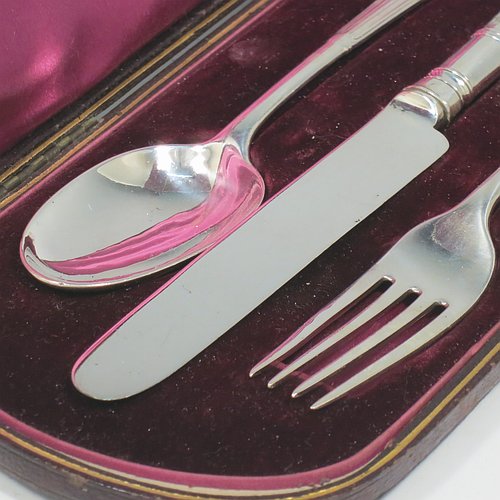 An Antique Victorian Sterling Silver christening set, having a knife, fork, and spoon, all with Albany pattern handles, and all sitting in their original purple satin and velvet-lined presentation box. Made by the William Gibson & John Lawrence of London in 1886 (for Goldsmiths & Silversmiths). The dimensions of this fine hand-made silver christening set are length of knife 20 cms (8 inches), with a total weight of approx. 125g (4 troy ounces).
