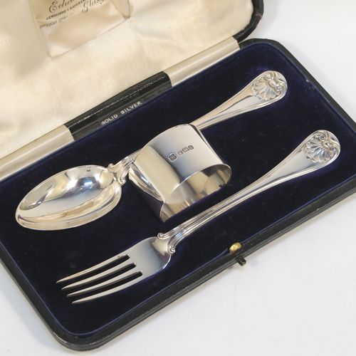 A very handsome Antique Sterling Silver christening set consisting of a plain round napkin ring, a spoon and fork in the double-struck Old English, Thread and Shell pattern, and all in their original cream satin and dark blue velvet-lined presentation box. This elegant silver christening set was mad by Martin Hall and Co., of Sheffield in 1912. The dimensions of this fine hand-made antique silver christening set are length of spoon and fork 16 cms (6.3 inches), diameter of napkin ring 4.5 cms (1.75 inches), and it has a total weight of approx. 124g (4 troy ounces).