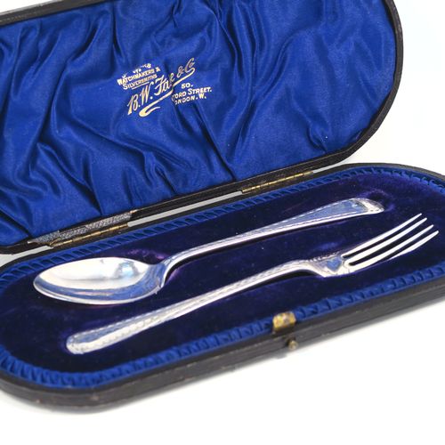 A very pretty Antique Sterling Silver christening set, having a fork and spoon in the Old English pattern, all hand-engraved on one side with a zig-zag border and stipple-work, and all sitting in their original dark blue satin and velvet-lined presentation box. This beautiful antique silver christening set was made by James Lewis and Sons  of Sheffield in 1911. The dimensions of this fine hand-made antique silver christening set are length 14 cms (5.5 inches), with a total weight of approx. 47g (1.5 troy ounces)   