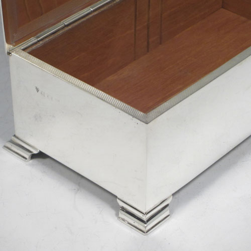 Sterling silver Art Deco style cigarette / cigar table box, having a very plain rectangular body with straight sides, hinged lid with thumb-piece, with engine-turned bands on inside border and lid, a wooden cedar-lined interior, and all sitting on four stepped corner feet. Made by J. B. Chatterley & Sons Ld., of Birmingham in 1955. The dimensions of this fine hand-made silver table box are length 17 cms (6.75 inches), height 6 cms (2.3 inches), and width 9.5 cms (3.75 inches).