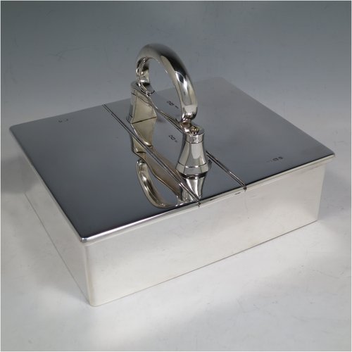 A Sterling Silver partners table cigar box, having a large plain rectangular body, with double hinged compartments opened by a mechanical carrying handle, and cedar wood-lined interiors. Made in London in 1933. The dimensions of this fine hand-made silver table cigar box are length 21 cms (8.25 inches), width 17 cms (6.75 inches), height inc. handle 14 cms (5.5 inches).   