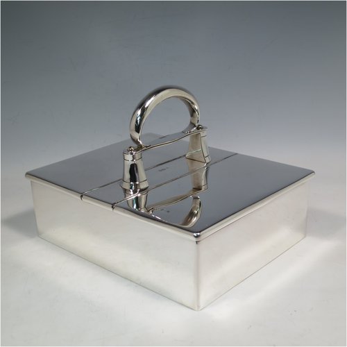 A Sterling Silver partners table cigar box, having a large plain rectangular body, with double hinged compartments opened by a mechanical carrying handle, and cedar wood-lined interiors. Made in London in 1933. The dimensions of this fine hand-made silver table cigar box are length 21 cms (8.25 inches), width 17 cms (6.75 inches), height inc. handle 14 cms (5.5 inches).