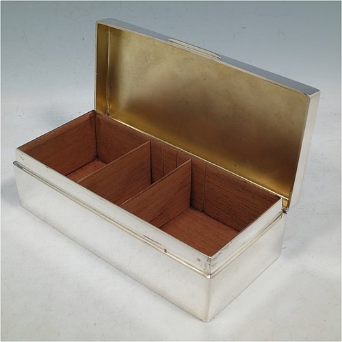 A Sterling Silver cigarette / cigar table box, having a plain rectangular body, with nice rounded corners, a hinged lid having an applied thumb-piece, and a gold-gilt and cedar wood-lined interior with two internal dividers. Made by Robert Comyns of London in 1932. The dimensions of this fine hand-made silver table box are length 19 cms (7.5 inches), width 9 cms (3.5 inches), and height 5.5 cms (2.25 inches). Please note that this item is crested.