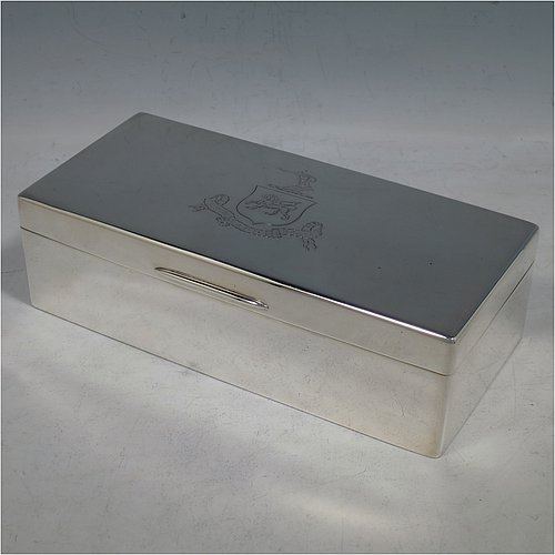 A Sterling Silver cigarette / cigar table box, having a plain rectangular body, with nice rounded corners, a hinged lid having an applied thumb-piece, and a gold-gilt and cedar wood-lined interior with two internal dividers. Made by Robert Comyns of London in 1932. The dimensions of this fine hand-made silver table box are length 19 cms (7.5 inches), width 9 cms (3.5 inches), and height 5.5 cms (2.25 inches). Please note that this item is crested.