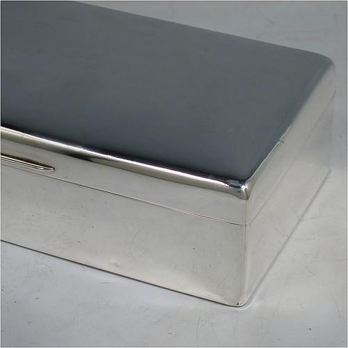 A Sterling Silver cigarette or cigar table box, having a plain rectangular body with nice rounded corners, a hinged lid having an applied thumb-piece, a gold-gilt interior to the lid, and a cedar wood-lined interior to the base, with a removable divider. Made by Alexander Clarke of London in 1925. The dimensions of this fine hand-made silver table box are length 17.5 cms (7 inches), width 9 cms (3.5 inches), and height 5 cms (2 inches).