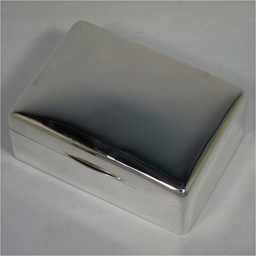 A handsome Antique Edwardian Sterling Silver cigarette / cigar table box, having a plain rectangular body with nice rounded corners, a hinged lid having an applied thumb-piece, and a cedar wood-lined interior to the base, with a removable divider. Made by Francis Higgins of London in 1905. The dimensions of this fine hand-made antique silver table cigar or cigarette box are length 13.5 cms (5.3 inches), width 9.5 cms (3.75 inches), and height 5.5 cms (2.25 inches).