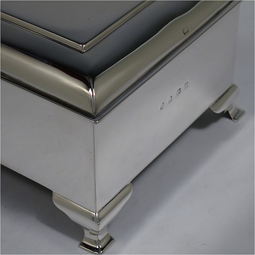 A large and very stylish Antique Edwardian Sterling Silver cigar / cigarette box, having a plain rectangular body, with a stepped and flat-topped hinged lid, a cedar wood-lined interior with internal divider, and all sitting on four cast stepped feet. Made by A. & J. Zimmerman of Birmingham in 1903. The dimensions of this fine hand-made antique silver table box are length 20 cms (8 inches), width 13.5 cms (5.25 inches), and height 9 cms (3.5 inches).