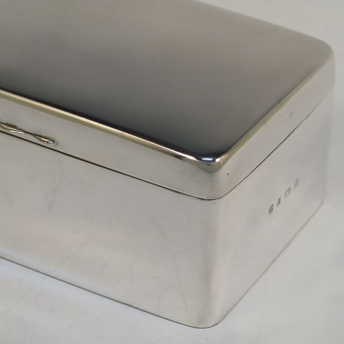 A very handsome Antique Edwardian Sterling Silver cigarette or cigar table box, having a plain rectangular body with nice rounded corners, a hinged lid having an applied thumb-piece, with a cedar wood-lined interior to the base and a removable divider. This elegant antique silver table box was made by A. and J. Zimmerman of Birmingham in 1903. The dimensions of this fine hand-made antique silver table cigar or cigarette box are length 17 cms (6.75 inches), depth 10 cms (4 inches), and height 7 cms (2.75 inches).